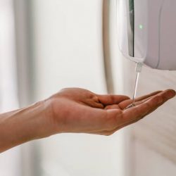 Asian woman hand using wash hand sanitizer gel dispenser automatic machine for prevent Coronavirus
